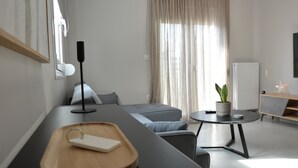 A modern living room with a sofa, a coffee table, and a small side table with a plant. - Charming 2-bedroom house in fantastic Trikala with AC, WiFi (Trikala)