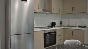 A modern kitchen with stainless steel appliances, beige cabinetry, and a marble countertop. - Charming 2-bedroom house in fantastic Trikala with AC, WiFi (Trikala)