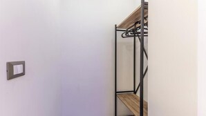 A room with a bunk bed, a wall-mounted light switch, and a wooden shelf. - Room 'Gordiani Guest House - Green' with Balcony, Wi-Fi and Air Conditioning (Roma)