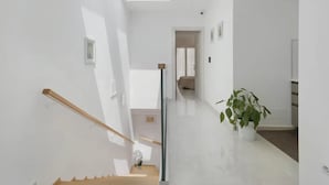Ein modernes Interieur mit Treppe, Blumentopf und Oberlicht.