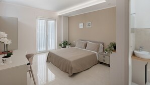 Ein modernes Schlafzimmer mit Bett, Nachttischen, Schreibtisch und einem Badezimmer.