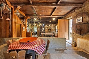 A rustic interior with wooden walls, a checkered tablecloth, and a stone wall with a sign. - Holiday Home 'Casa Do Riacho - Douro' with Mountain View, Private Terrace and Wi-Fi (Armamar)