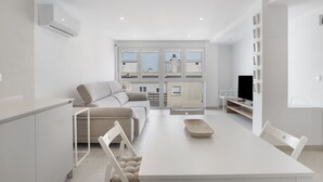 Una sala moderna con un sofá, una mesa de comedor y un televisor.