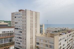 Un immeuble résidentiel de grande hauteur, doté de nombreux balcons, d’un toit plat et offrant une vue sur la mer.