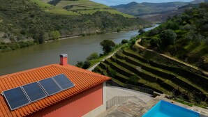 A terraced vineyard with a river, a red-roofed building with solar panels, and a swimming pool. - Property In A Holiday Village 'Quinta Da Pedra Caldeira B' with Mountain View and Air Conditioning (Armamar)