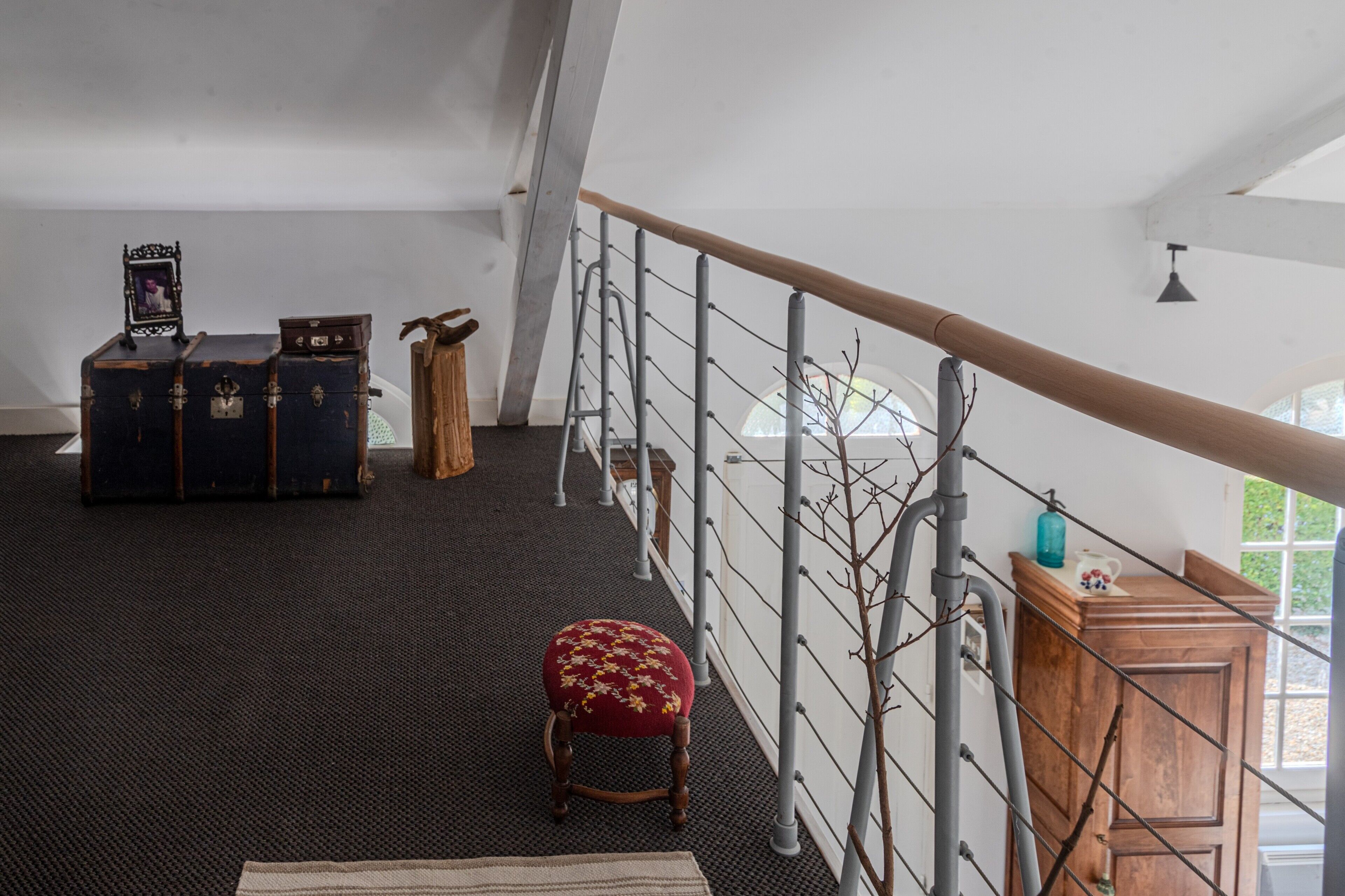 Ein Zimmer mit Treppe, einer hölzernen Bank und alten Koffer.