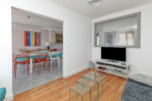 A modern living room with a flat-screen TV, a glass coffee table, and a grey sofa. - Holiday Home 'Maison De Famille Paisible' with Private Terrace and Wi-Fi (Le Pouliguen)