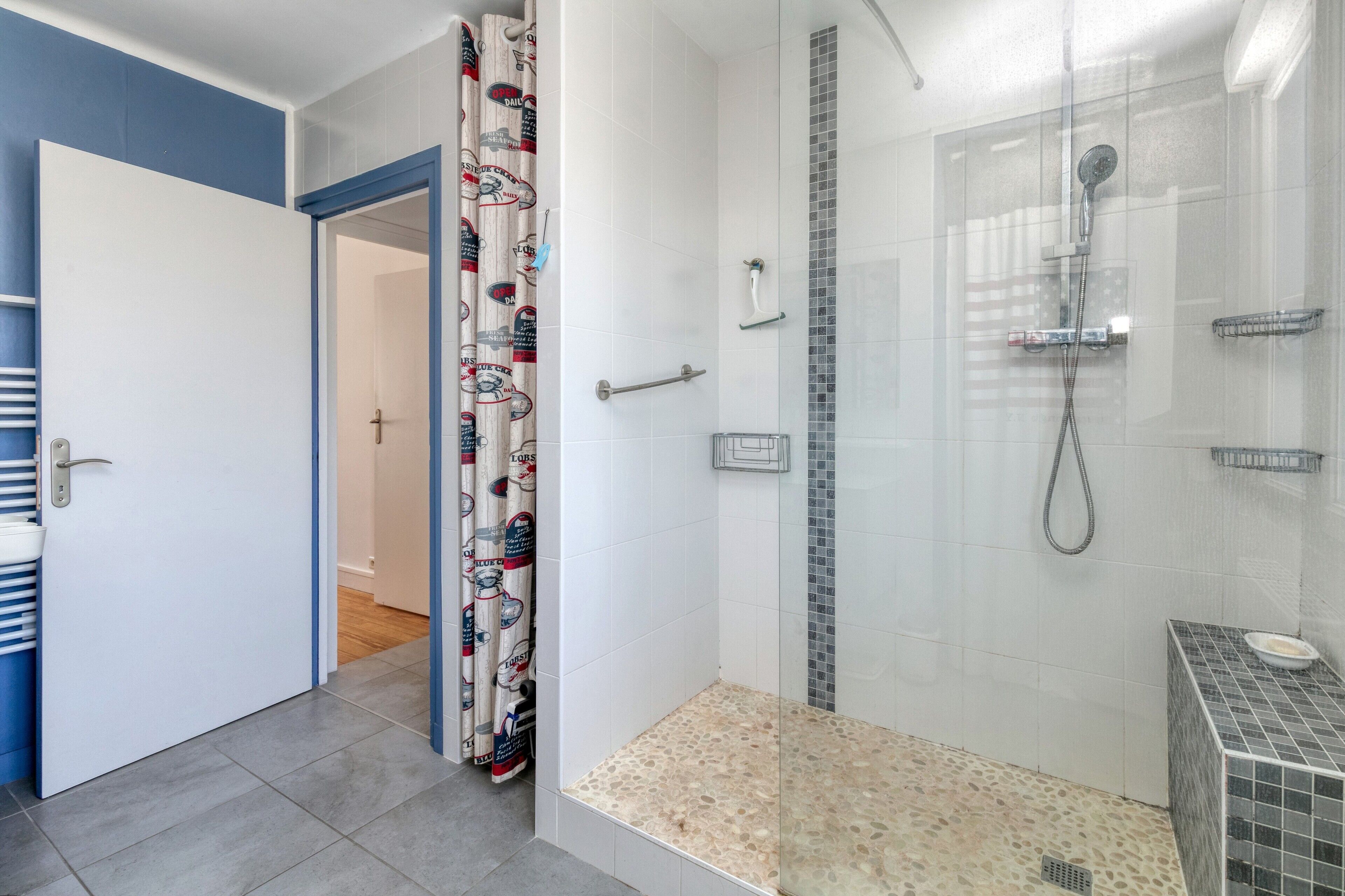 A bathroom with a shower, a toilet, and a sink.