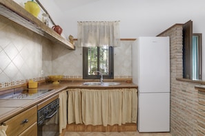 A kitchen with a built-in oven, a sink, and a refrigerator.