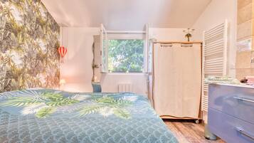 Une chambre à coucher avec un lit, une fenêtre, une armoire et un radiateur.