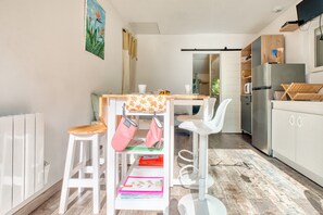 Une cuisine moderne avec des meubles blancs, une table à manger en bois et une chaise blanche.