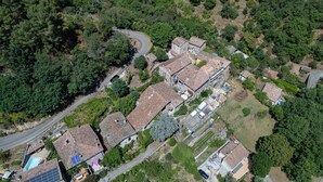 An aerial view of a residential area with houses, a winding road, and dense greenery. - Le Bacci Country House with Mountain View, Private Garden & Wi-Fi (Vals-les-Bains)
