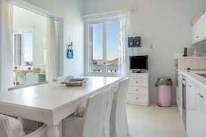 A kitchen with a dining area, a TV, and a view of the landscape.