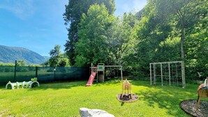Leikkikentällä on liukumäki, keinut ja kiipeilyteline.