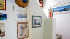 Una escalera con un cuadro en la pared, un farol decorativo y otra obra de arte enmarcada.