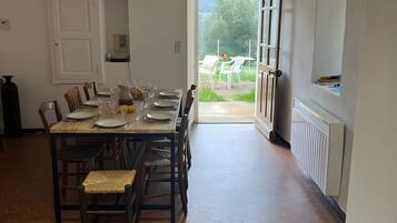 A dining area with a table set for four, a radiator, and a view of the outdoors.