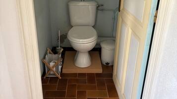 Ein kleines Badezimmer mit Toilette, Bidet und Mülleimer.