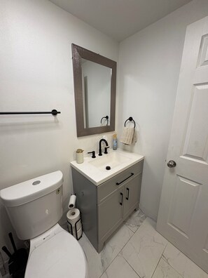 Chuveiro, toalhas de banho, sabonete, papel higiênico