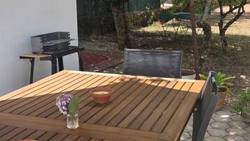 Ein Holztisch mit zwei Terrakotta-Kerzen und einer kleinen Vase mit Blumen.