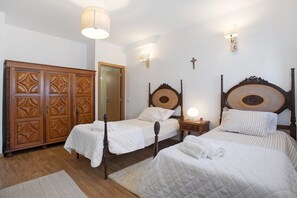 A bedroom with two single beds, a wardrobe, and a mirror.