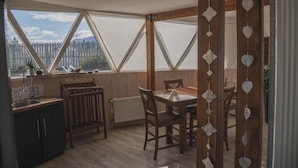 Une cuisine avec des meubles de rangement en bois, un évier et un coin repas comprenant une table et des chaises.