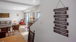 Un escalier sur lequel est affiché un panneau indiquant les règles de la maison en portugais.