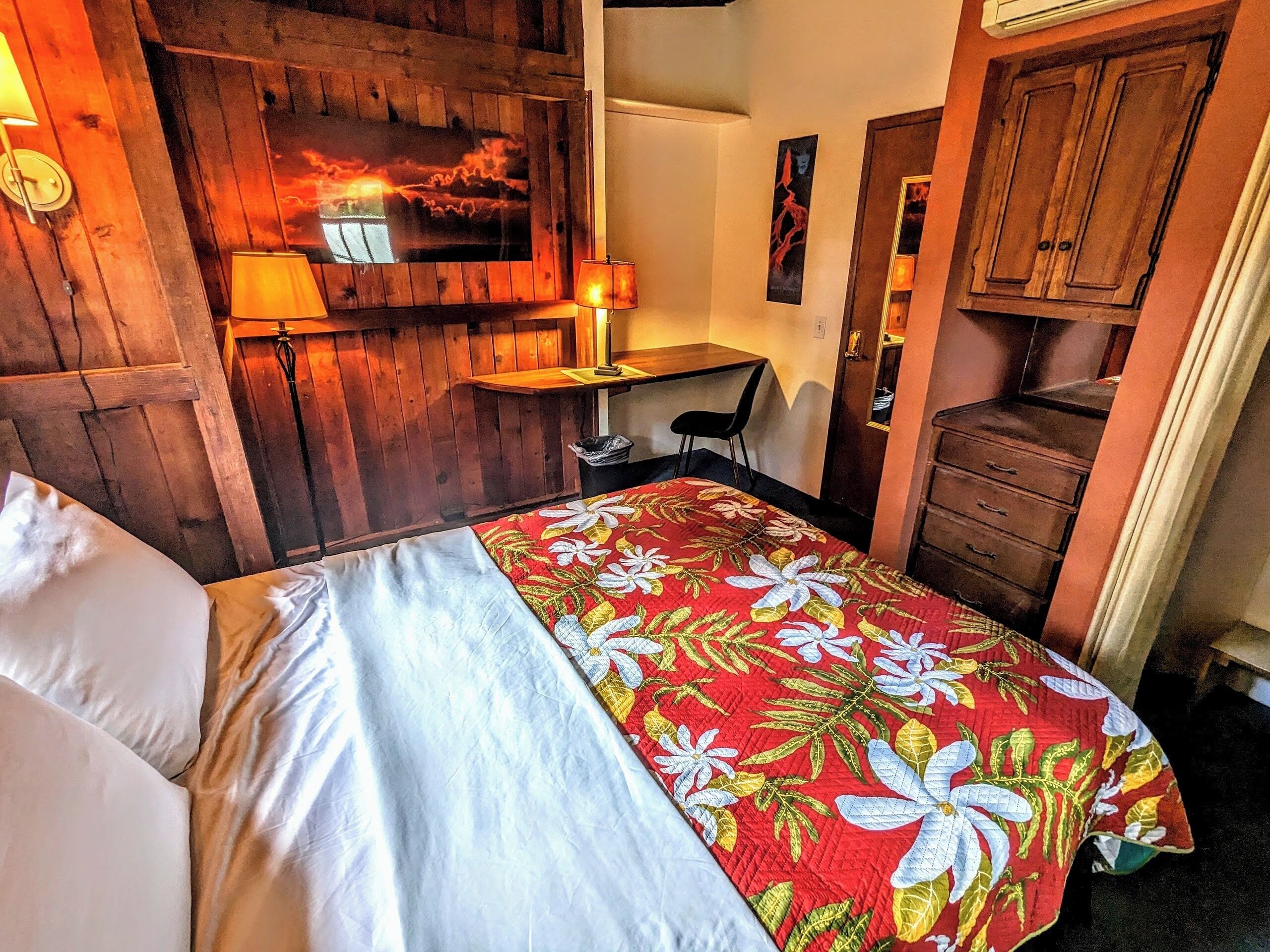 A room with a bed, a desk, and a wardrobe.