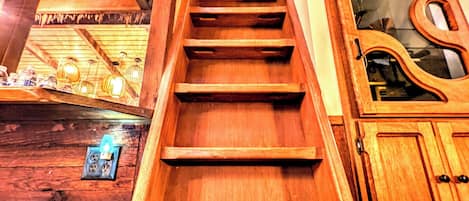 A wooden staircase with a handrail leading to a higher floor.