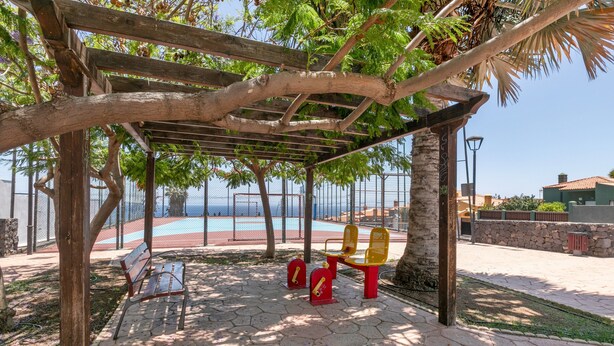 Un parc doté d’une pergola en bois, de bancs et d’équipements de musculation.