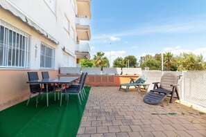 A patio with a table and chairs, a green artificial turf area, and a brick floor. - Global Vacacional: Ground floor with pool in Almenara (Almenara)