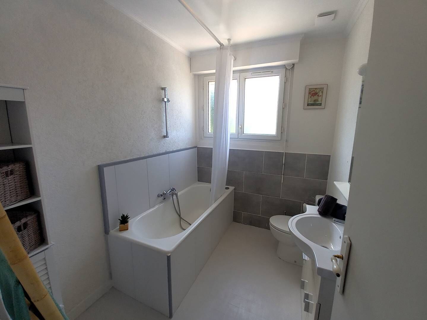 A bathroom with a bathtub, a toilet, and a sink.