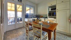 A kitchen with a wooden table and chairs, a coffee machine, and a microwave.