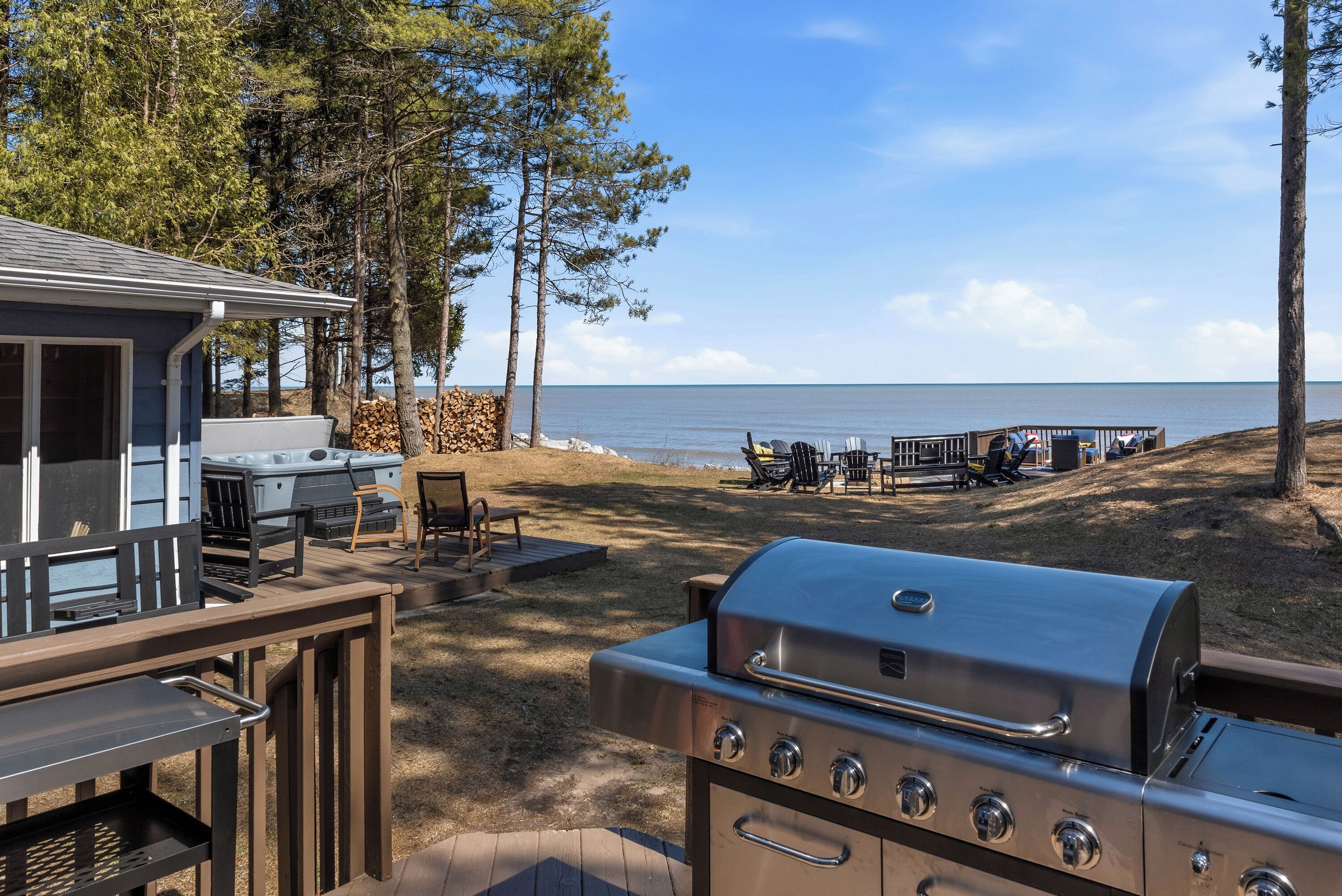 A patio area with a grill, outdoor seating, and a view of the ocean.