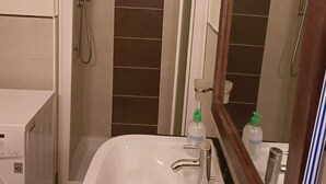 A bathroom with a white sink, a mirror, and a shower area. - Marialva Tropical T2 (Santa Maria)