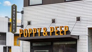 Un bâtiment sur lequel on peut lire l’inscription « Poppy & Peep Chocolate » et un autre panneau indiquant « Chocolat ».