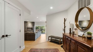A modern interior with a wooden floor, a patterned rug, a wooden console table, and a large mirror. - The Summit Stay | Pool | Pickleball | Hot Tub (Sun Valley)