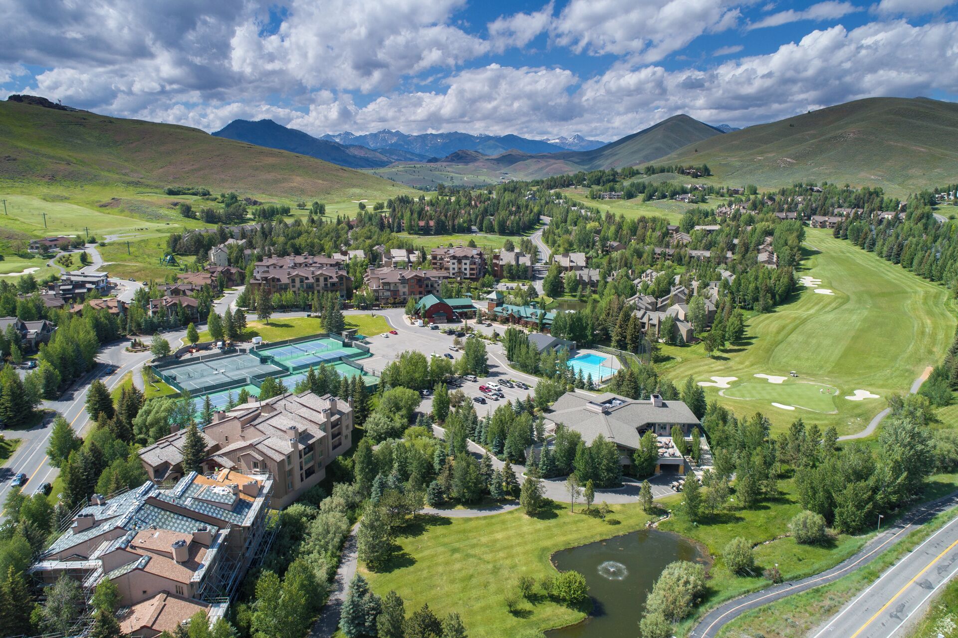 A resort with multiple buildings, a swimming pool, and a golf course.