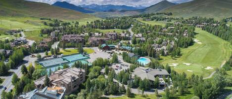 A resort with multiple buildings, a swimming pool, and a golf course.
