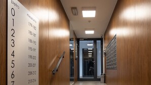 A modern elevator interior with a wooden wall and a floor plan sign.