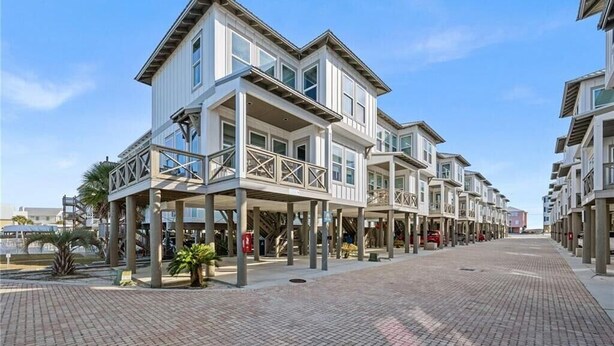 Ein Strandhotel mit mehreren Etagen, Balkonen und einem überdachten Gang.
