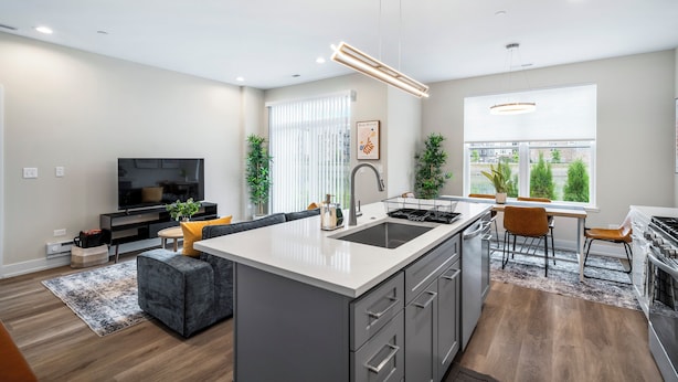 Una cocina moderna con una isla central, electrodomésticos integrados y un comedor con vistas.
