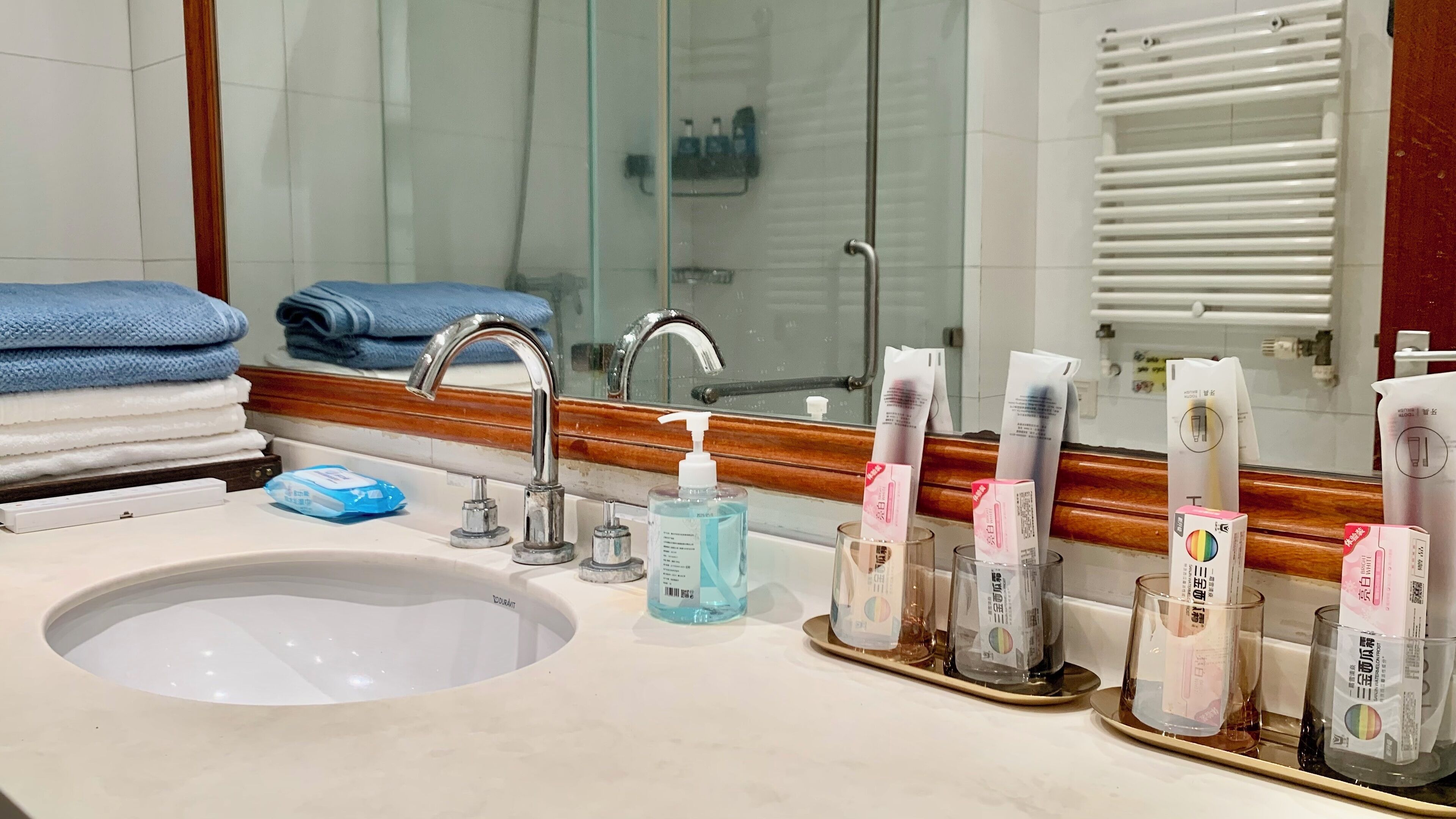 A bathroom with a sink, mirror, and toiletries.