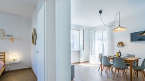 Un apartament modern amb zona de menjador, cuina i dormitori.