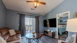 A living room with a brown leather sofa, a round coffee table, and a TV mounted on the wall. - 2BR Lake View Indian Point Condo Next to Silver Dollar City | (GF17-5) (Branson)