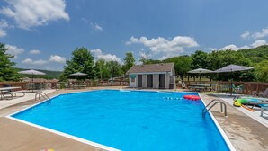 A rectangular swimming pool with a wooden deck surrounding it, equipped with lounge chairs and umbrellas. - 2BR Lake View Indian Point Condo Next to Silver Dollar City | (GF17-5) (Branson)
