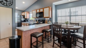 A modern kitchen with wooden cabinets, a central island, and bar stools. - 2BR Lake View Indian Point Condo Next to Silver Dollar City | (GF17-5) (Branson)