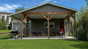 A covered patio area with a grill and outdoor seating.