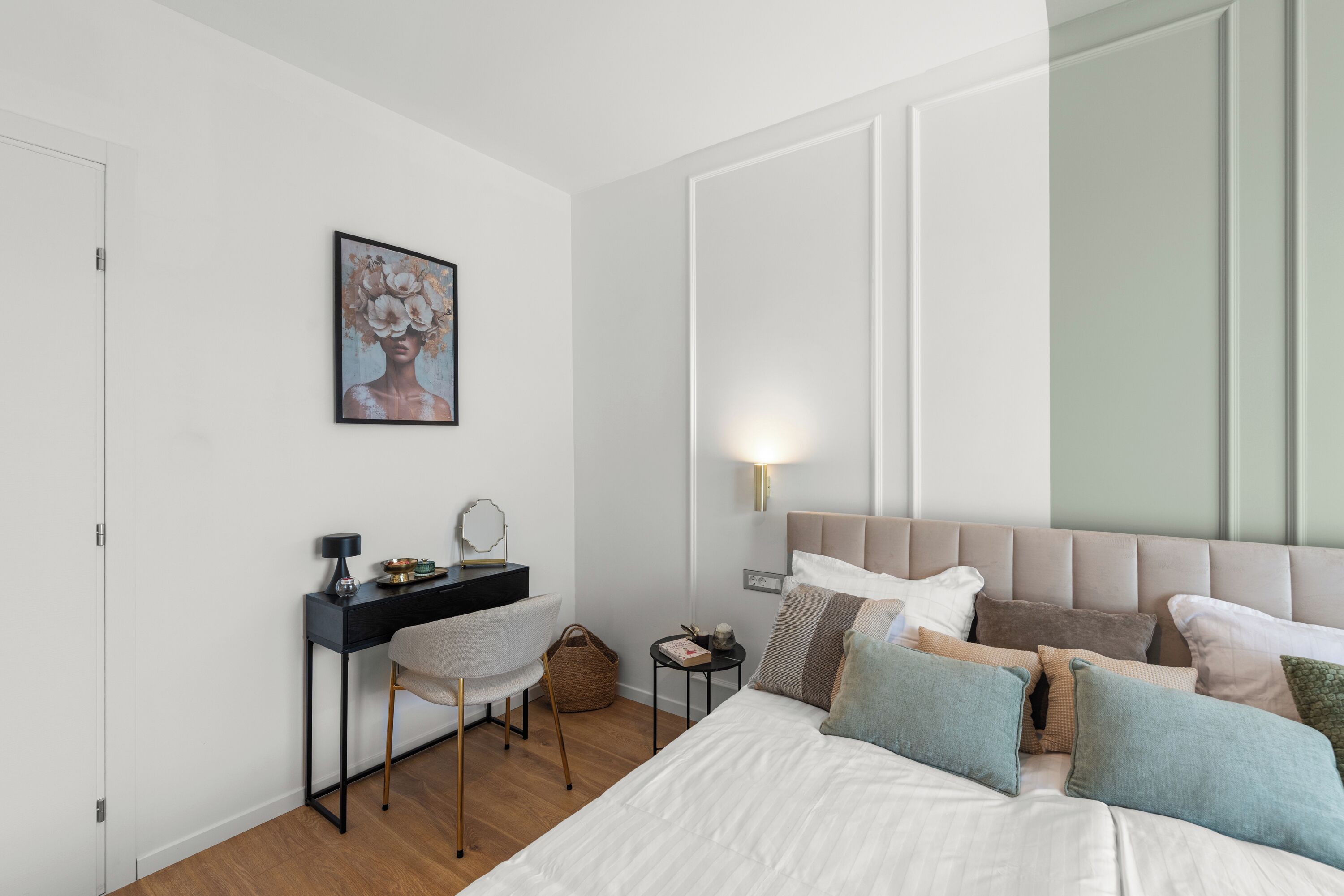 Une chambre à coucher comprenant un lit, une table de chevet, une lampe, un bureau, une chaise et une œuvre d’art encadrée accrochée au mur.