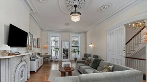 Ein geräumiges Wohnzimmer mit Kamin, Fernseher und einer Treppe zu einer weiteren Ebene.