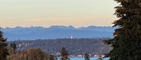 Ein Zelt in einer bewaldeten Gegend mit Blick auf Berge und einen Leuchtturm in der Ferne.